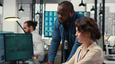 Rapor oluşturmak için aylık veri grafiklerini inceleyen çeşitli ofis çalışanları, yenilikçiliği teşvik etmek ve şirket performansını artırmak için iş stratejisi ve analizler uyguluyorlar. İş birliği. Kamera B.