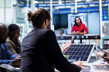 Güneş paneli fabrika yönetimi yatırımcılarla görüntülü konuşma yaparak üretim stratejilerini sergiliyor. Hissedarların üretim büyüme verilerini sunmak için video konferansı düzenleyen Photovoltaics fabrikası yöneticileri