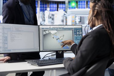 PC 'yi kullanarak fotovoltaik fabrikasındaki programcı robot silahlarını güncelliyor güneş panellerini montaj hattına yerleştiriyor, takım lideriyle iletişim kuruyor, yakın çekim yapıyor.