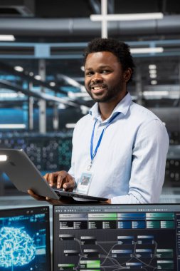 Veri merkezindeki gülümseyen mühendisin portresi yapay zeka bilgisayarlı model kullanıyor. Yapay zeka öğrenme algoritmalarıyla çalışan mutlu sunucu odası bilişim uzmanı