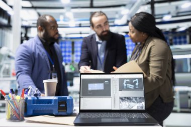 Çok ırklı iş ortakları, üretimle ilgili sorunları çözmek için bir güneş enerjisi tesisinde bir araya gelerek mühendislik uzmanlığı ve işbirlikçi problem çözmeyi birleştiriyor. Fotovoltaikler.