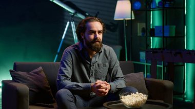 Coşkulu bir spor hayranı evinde canlı yayında en sevdiği takım golünü kutlamak için bağırıyor. Öforik adam bağırıyor, çılgınca el hareketi yapıyor, kaleye bayılıyor, kamera A