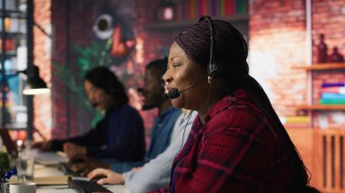 Ofisteki arkadaş canlısı müşteri yöneticisi, müşteri ilişkilerini sürdürerek ipuçları yaratıyor. Neşeli Afrikalı Amerikalı çalışan müşteriyle konuşuyor, yeni satış fırsatlarını belirlemek için, kamera A