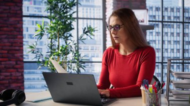 Olgun kişi iş programını denetliyor ve masasında planlama faaliyetleri yapıyor, dijital aletlerle zaman yönetimi üzerinde çalışıyor. Serbest çalışan bir kadın bilgisayar ve çoklu görevleri kullanıyor. Kamera B.