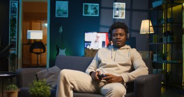 Sıkılmış adam çevrimiçi video oyunu oynuyor ve modern dairesindeki saldırı tuşlarına spam atıyor. İnternet ve spor müsabakalarına katılan neon ışıklı uzay oyuncusu. Kamera B.