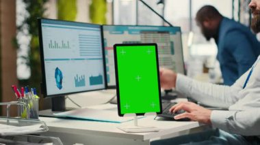 İşletme danışmanı, tablette krom anahtarı olan tahminleri inceliyor, brifing için performans ölçümleri üzerinde çalışıyor. Küresel genişleme ve ağ oluşturma için rakamlar artıyor. Kamera B.