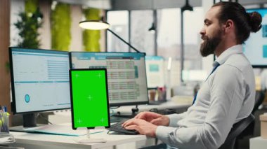 Erkek yönetici grafikler ve izole edilmiş maket ekran ile çalışarak uluslararası piyasada iş başarısı sağlıyor. Ofisteki küresel genişleme stratejisinin verileri gözden geçiriliyor. Kamera B.