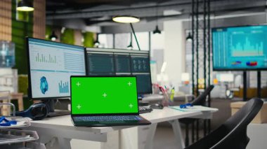 Boş şirket ofisinde dijital kaynaklar ve dizüstü bilgisayar, rapor yazma, strateji geliştirme ve örgütsel hedeflerin sıralanması için hazır çalışma alanı yer alıyor..