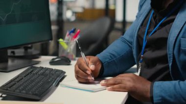 Siyahi çalışanlar notlarla yeni bir kalkınma stratejisi geliştiriyor, öngörü projesi sonuçlarına ilişkin verileri ve çözümleri analiz ediyorlar. Erkek profesyonel ofiste brifing raporları üzerinde çalışıyor. Kamera B.