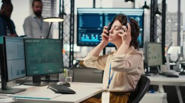 Ofis yöneticisi görevleri çözmek, iş istasyonundaki performans ölçümlerini izlemek için kulaklık üzerine odaklanmış müzik kullanır. Girişimciliğin üretkenliğini ve başarısını sağlamak için idari görevler. Kamera B.