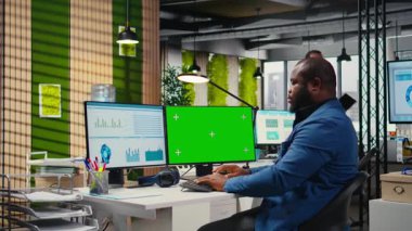 Afrika kökenli Amerikalı bir adam yeşil ekran ile iş planlama ile meşgul, hedeflerle aynı hizayı sağlamak ve performans ölçümlerini optimize etmek için yazma rapor eder. Şirket hava durumu. Kamera A.