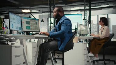 Siyahi erkek analist, dijital araçlarla bilişim şirketinin gelişimine, analizlere ve iş yerindeki performans ölçümlerine odaklandı. Personel planlama çözümleri ve hedefleri hizalamak. Kamera A.