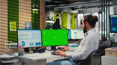 Ofiste yeşil ekran ile iş planlaması yapan çalışanlar, hedeflerle aynı hizayı sağlamak ve performans ölçümlerini optimize etmek için yazma raporları hazırlarlar. Şirket hava durumu. Kamera A.