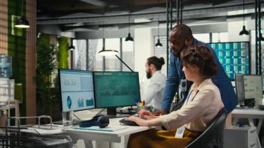 Rapor oluşturmak için aylık veri grafiklerini inceleyen çeşitli ofis çalışanları, yenilikçiliği teşvik etmek ve şirket performansını artırmak için iş stratejisi ve analizler uyguluyorlar. İş birliği. Kamera A.