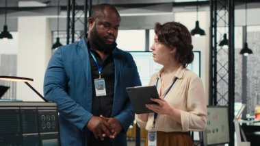 Çeşitli işçiler büyüme stratejisini geliştirmek için dijital araçlar ve analizler kullanırken, modern ofis ortamında yenilik ve kalkınmayı teşvik etmek için tablet üzerindeki mali görüşleri gözden geçiriyorlar. Kamera B.