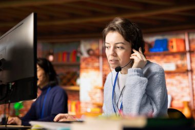 Arama merkezi çalışanı mikrofonla konuşuyor, müşterilerin hesaplara ve cihazlara tekrar erişmelerine yardım ediyor. Parolayı sıfırlamak için yardıma ihtiyacı olan müşteri desteği