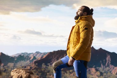 Maceraperestler önlerindeki vadiye ve dağ zirvelerine bakar. Açık arazinin özgürlüğünü hisseder. Genç kaşif tam donanımlı yüksek rakımlı açık hava keşiflerinin tadını çıkarıyor..