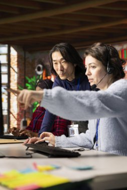 Tecrübeli çağrı merkezi uzmanları kadınlara bilgisayar araçlarının nasıl kullanılacağı konusunda eğitim veriyor. Stajyere şirket platformlarının nasıl kullanılacağını gösteren Asyalı üst düzey yönetici.