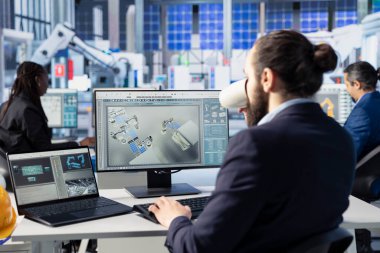 Fotovoltaik fabrikasındaki mühendis PC 'de kahve içiyor ve çalışan sistemleri teşhis ediyor. Güneş panellerinde içecekten hoşlanan bir adam fabrika üretiyor, dinlenme süresini azaltıyor, kamera A