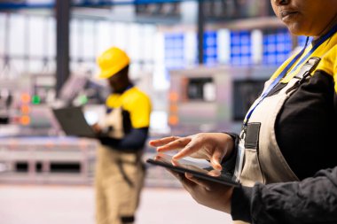 Kadın mühendis endüstri geliştirme 4.0 sistem verileri tablet, akıllı otonom fabrikada sorun çıkarma sorunları. Endüstriyel otomasyon için dijital çözümler kullanan Afrikalı Amerikalı teknisyen.