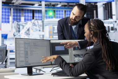 Photovoltaics fabrika müdürü, kodlama görevlerindeki ilerlemeyi kontrol etmek için sistem yöneticisi masasına geliyor. Güneş panelleri ekip lideri çevresel olarak güvenli güneş pilleri inşa eden yönetici ile konuşuyor.