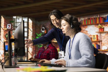 Gülümseyen Asyalı çağrı merkezi müdürü şirket stajyerlik performansını değerlendiriyor. Müşteri hizmetleri müfettişi, gemide yeni çalışan teknik elemanını denetliyor.