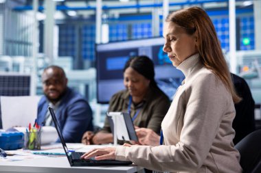 Bilgisayardaki fotovoltaik fabrika izleme sistemi performansı yatırımcısı. Güneş panelleri enerji üretimi ve verimliliğini izlemek için dizüstü bilgisayar kullanarak fabrika yöneticisi üretiyor.