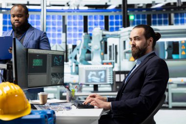 Erkek fabrika çalışanı, güneş paneli fabrikasındaki bakım ve sistemleri inceliyor, ekipmanların işlevselliğini sağlıyor ve güvenilir, sürdürülebilir endüstriyel operasyonlara katkıda bulunuyor..