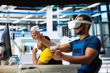 Dijital güneş enerjisi üretmek için VR kulaklığı kullanan fotovoltaik mühendisi, fabrikadaki robot kolları aracılığıyla güneş panelleri yerleştirdi. Sanal gerçekliği kullanarak üretim hattını denetleyen adam uzmanı.