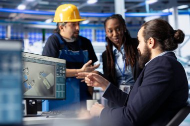 Fotovoltaik fabrika yöneticisi güneş mühendisliği ekibiyle çalışıyor, sistemlerin güvenilirliğini arttırıyor. Alternatif enerji güneş paneli üretim tesisi uzmanı işçilere geri bildirim sağlıyor