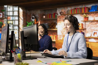 Neşeli çağrı merkezi ajanı, ses kulaklığıyla konuşuyor, müşterilerin hesaplara ve cihazlara tekrar erişmelerine yardım ediyor. Neşeli müşteri destek uzmanı parolayı sıfırlamak için yardıma ihtiyacı olan müşterilere yardım ediyor