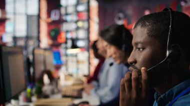 Destek veren merkezi ara, müşterileri şikâyet et, mikrofonla konuş. Çalışan memnuniyetsiz müşterilerle ilgileniyor, kulaklık mikrofonuyla konuşuyor, kamera B aşırı yakın plan.