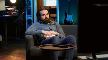 Stres yüzünden patlamış mısır yiyen üzgün adam canlı yayında acıklı bir dram filmi izliyor. İnsan yiyen, TV 'den rahatsız olan favori karakter ölüyor, kamera A