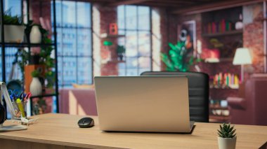 Modern dekorasyonlu boş bir minimalist daire ve masa, uzaktan çalışma için kullanılan ev ofisi. Çağdaş ahşap döşemeleri ve bitkileri olan modaya uygun bir çatı katı..