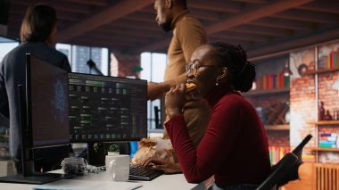 Başlangıçta yapay zeka algoritmasını programlayan programcı, makine öğrenme modellerini rafine ederken masada yemek yiyor. Stresli kadın Silikon Vadisi ofisinde kodlama platformu kullanıyor ve atıştırmalıkların tadını çıkarıyor, kamera A