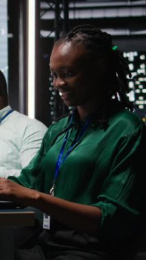 Gülümseyen siyah analistin dikey video portresi önemli bir toplantıya hazırlanıyor, saatler sonra kalkınma fonlarını artırıyor. İş arkadaşları hedef belirleme tartışmasına katıldı