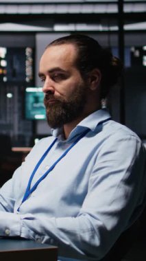 Dikey Video Erkek Muhasebe Müdürü aylık giderleri gözden geçirir, iş ekibiyle gece vakti laptoptaki veri güncellemelerini gözden geçirir. Mesai sonrası sahnesi. Kamera.