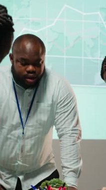 İşletme hedeflerini modern bir şirkette yatırımcıların beklentileriyle aynı hizaya getirmek için şirket brifinginde işbirliği yapan, projeksiyonları ve analizleri destekleyen dikey video çeşitliliği grubu