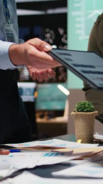 Takım çalışması için düzenlenen bir brifinge katılan Dikey Video İş Meslektaşları, belgeleri değiş tokuş ve finans güncellemelerini gözden geçirdiler. Sorunları çözerek hedefleri hizalamak. Kamera A.