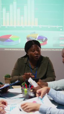 Veri içgörülerini ve kağıt üzerindeki mali durumu gözden geçiren, hissedarlar için güncellemeler hazırlayan ve proje gündemini ve hedeflerini belirleyen çok ırklı bir danışman grubu