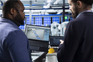 Çok ırklı güneş paneli mühendisliği ekibi, temiz yenilenebilir enerji üretimi üzerinde çalışarak fabrikada veri bilgilerini paylaşıyor. Yenilik ve takım çalışması ile sürdürülebilir gücü desteklemek.