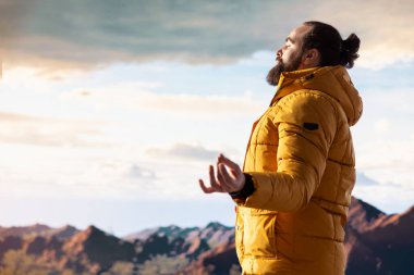 Dağın tepesinde meditasyon yapan maceraperest, tepeye başarıyla tırmanıyor ve manzaranın tadını çıkarıyor. Genç sakin zen yolcusu yürüyüş ve meditasyon yapıyor..