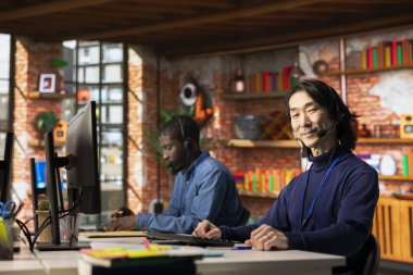 Moral verici çağrı merkezi kıdemli ajanının portresi mikrofonla konuşuyor, müşteriye adım adım rehberlik ediyor. Neşeli Asyalı müşteri merkezi çalışanı mikrofonla konuşuyor.