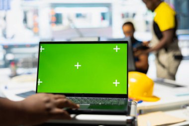 Photovoltaics fabrikası uzman sistem ayarları yeşil ekranda. Çalışan, güneş panellerinde dizüstü bilgisayar üzerinde çalışıyor. Montaj hatları yapılandırması için fabrika üretiyor..