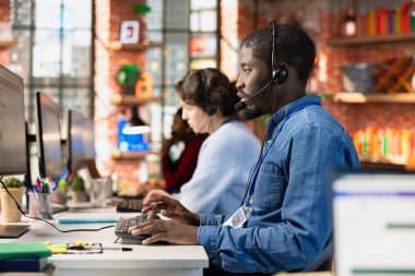 Çağrı merkezi ajanlarından oluşan çok ırklı bir ekip, müşteri aygıtlarına bağlanmak ve hataları düzeltmek için uzaktan erişim araçları kullanıyor. Çeşitli müşteri merkezlerindeki işçiler, müşterilere yazılım yüklemede yardımcı oluyorlar