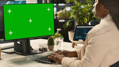 Ofis memuru gelir ve karlılık için kilit performans hedeflerini vurmak için yeşil ekran modelleme bilgisayarı üzerinde çalışıyor. Chroma Key Bilgisayar Masası çalışanı. Araştırma analizi yapıyor. Kamera A.