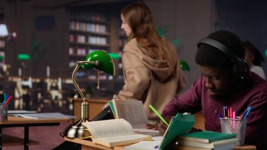 Afrikalı Amerikalı erkek öğrenci okul ödevlerinde yardımcı olmak için ortam odaklı müzik kullanır, üniversite veritabanından ve diğer akademik kaynaklardan alıntılar toplar. Kamera A.