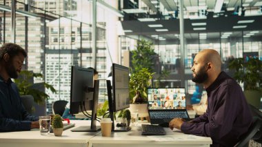 Çalışan, iş arkadaşlarıyla görüntülü görüşme yapıyor. Ofiste çalışıyor. İnternet üzerinden tele-çalışan iş arkadaşlarıyla video konferansında çalışan personel, kamera B