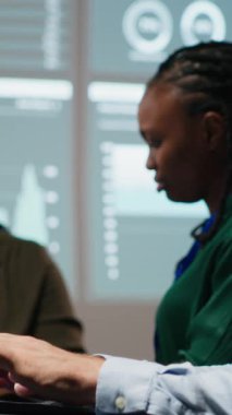 Dikey Video Erkek Muhasebe Müdürü aylık giderleri gözden geçirir, iş ekibiyle gece vakti laptoptaki veri güncellemelerini gözden geçirir. Mesai sonrası sahnesi. Kamera.