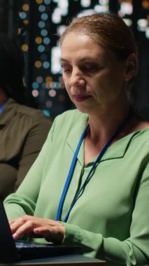 Dikey Video Kadın Yöneticisi ve personeli şirket içindeki verimlilik ölçümlerini inceleyerek bir toplantı sırasında proje içgörüsü sunuyorlar. Üretkenlik için veri raporları ve tahminleri. Kamera.